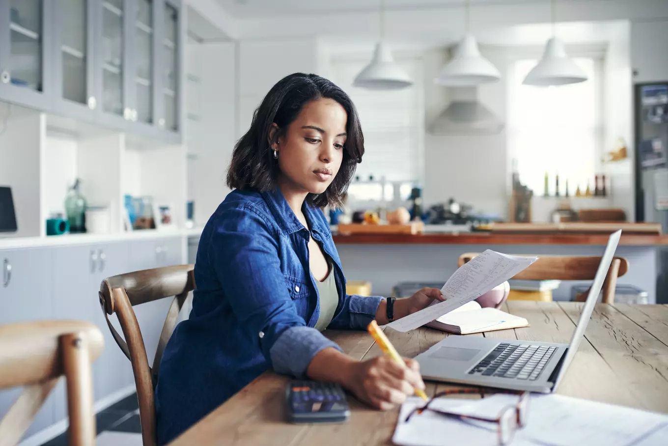 Women sitting at table looking at laptop.