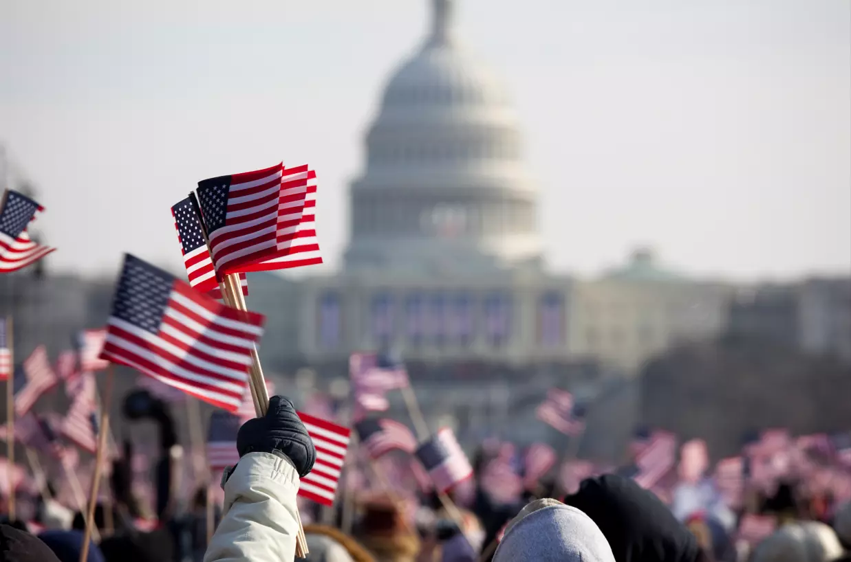 Hand waving American flag outside US Capitol building